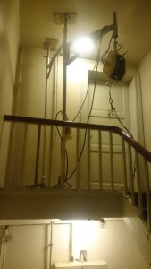 Piperør heises opp til loft gjennom trappeløp.